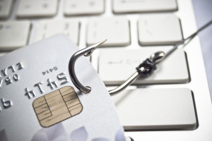 hand holding a credit card with a fish hook - phishing
